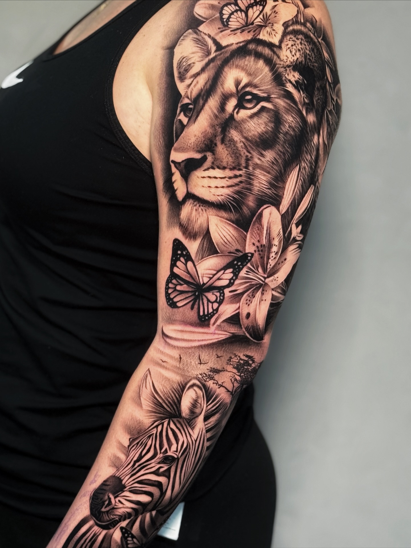León y mariposas brazo